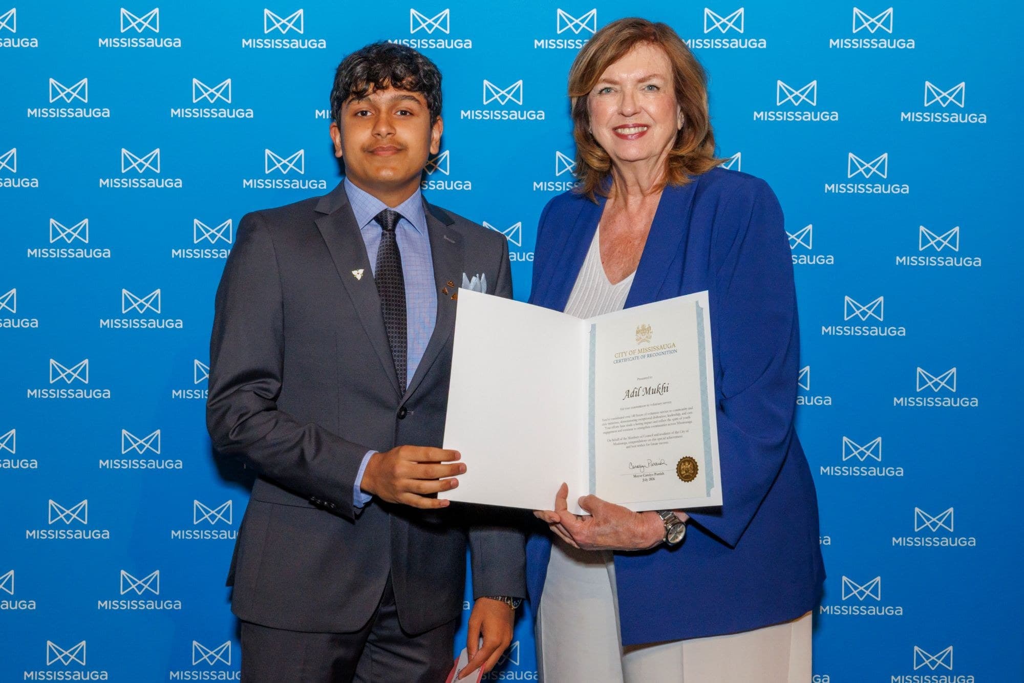 Adil Mukhi receiving a certificate of recognition from Mississauga Mayor Carolyn Parrish