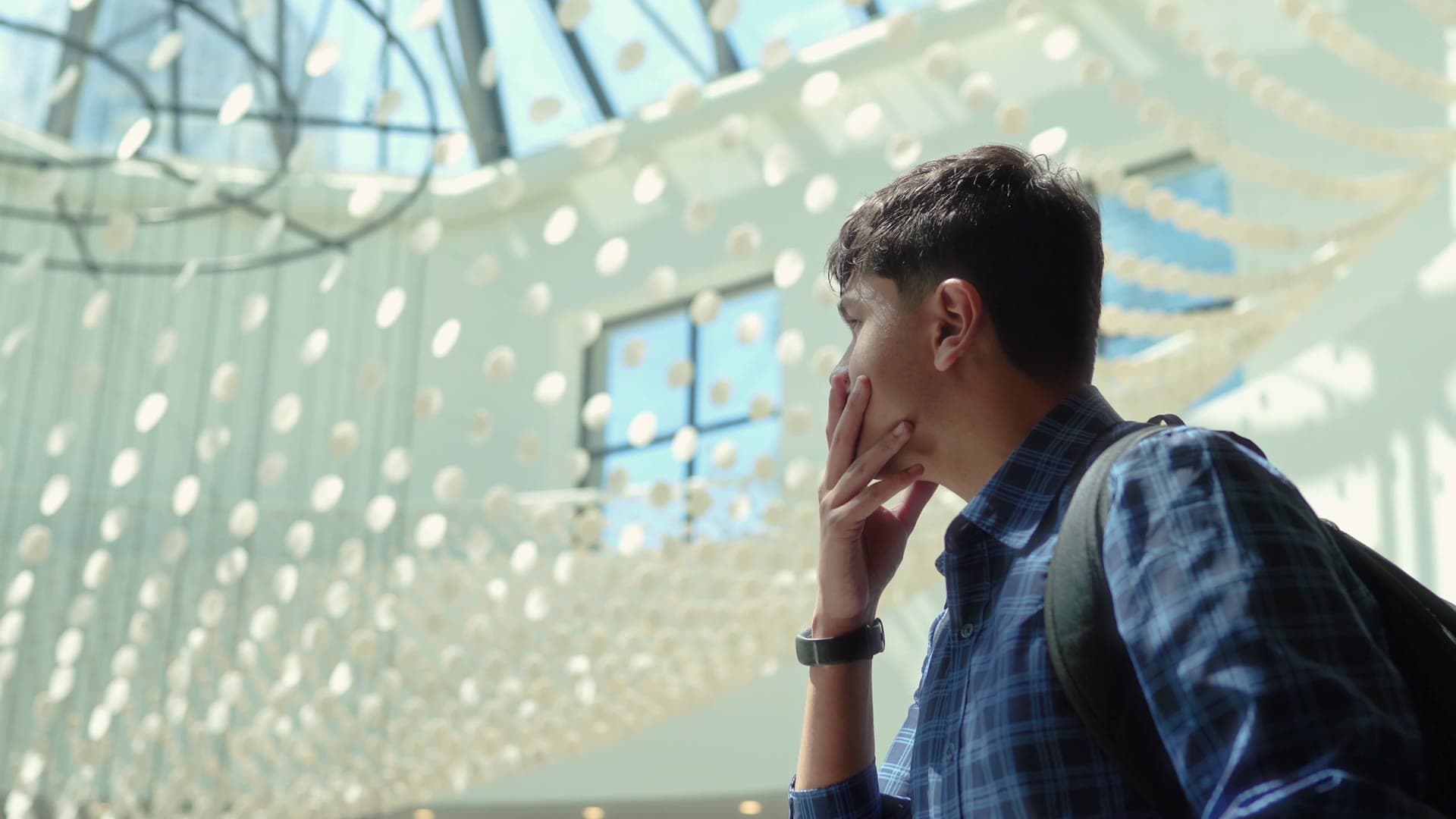 Adil Mukhi looking up in a bright atrium