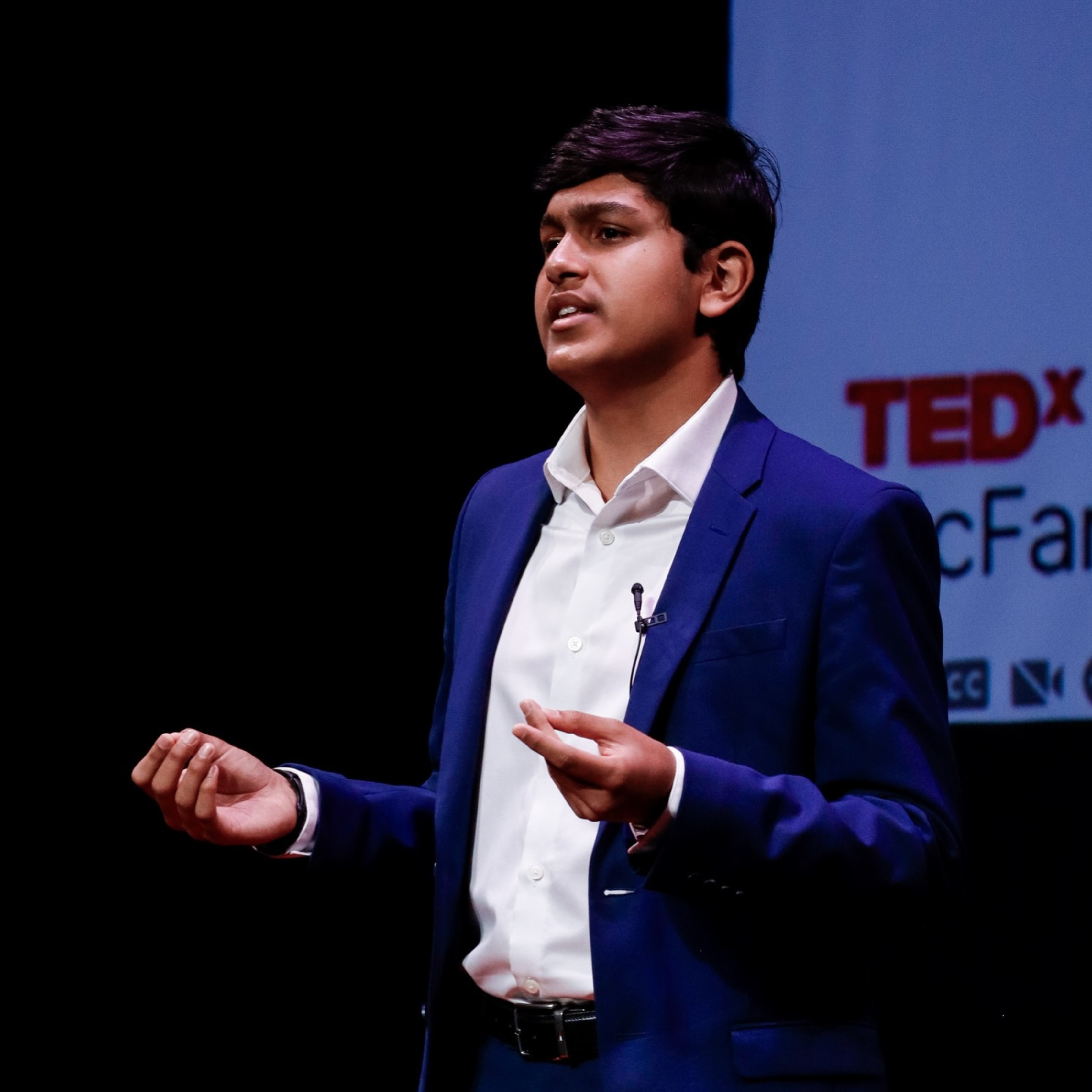 Adil Mukhi at TEDx with event backdrop