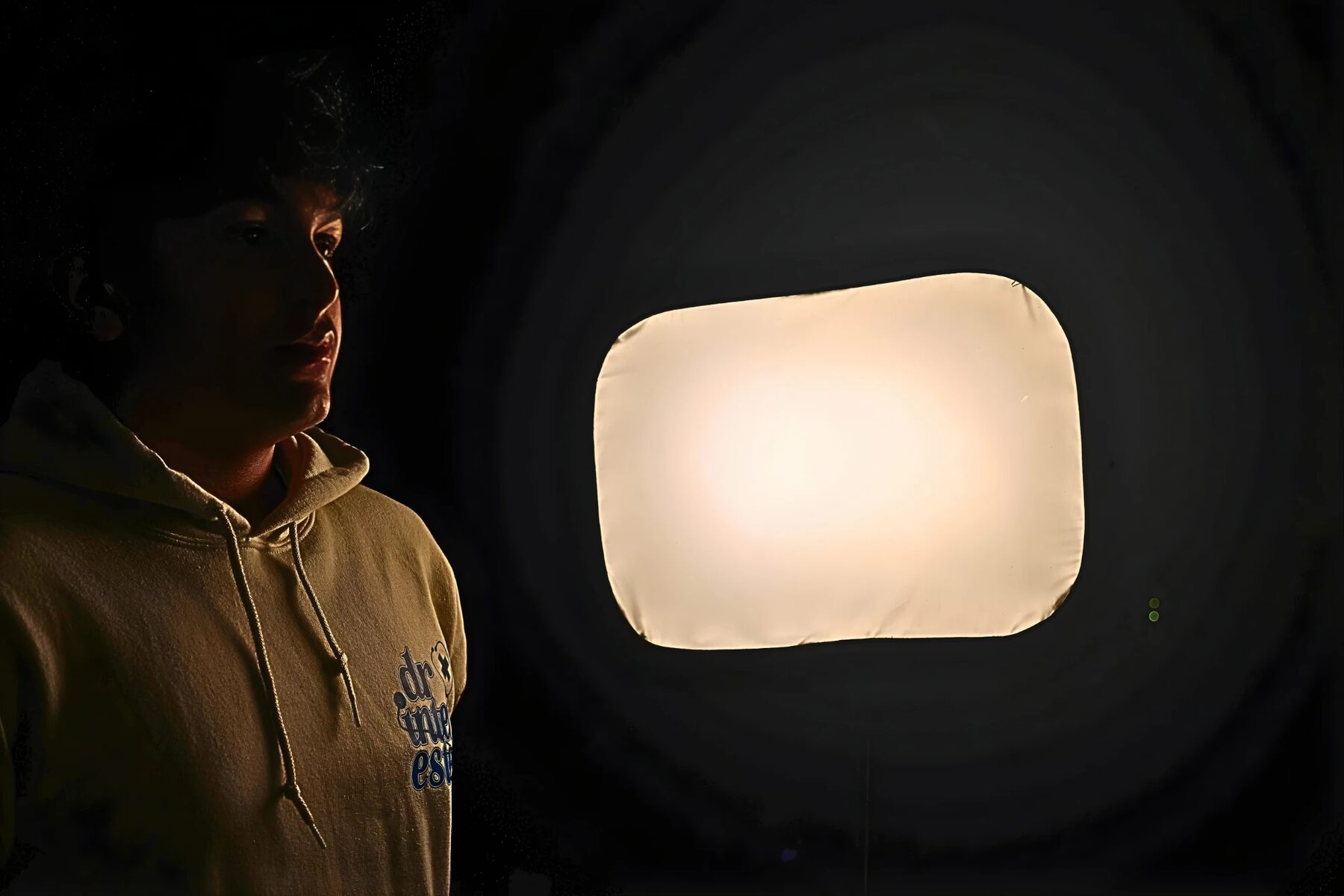 Adil Mukhi in a Dr. Interested hoodie lit by a studio light
